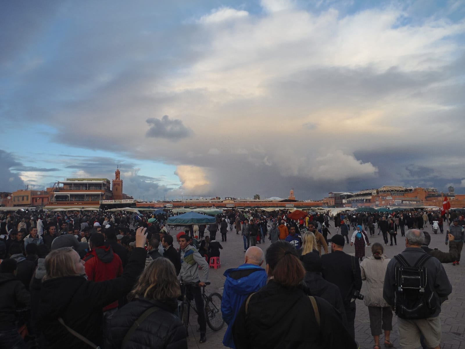 Crowds on Jemaa el-Fna square under an evening sky
