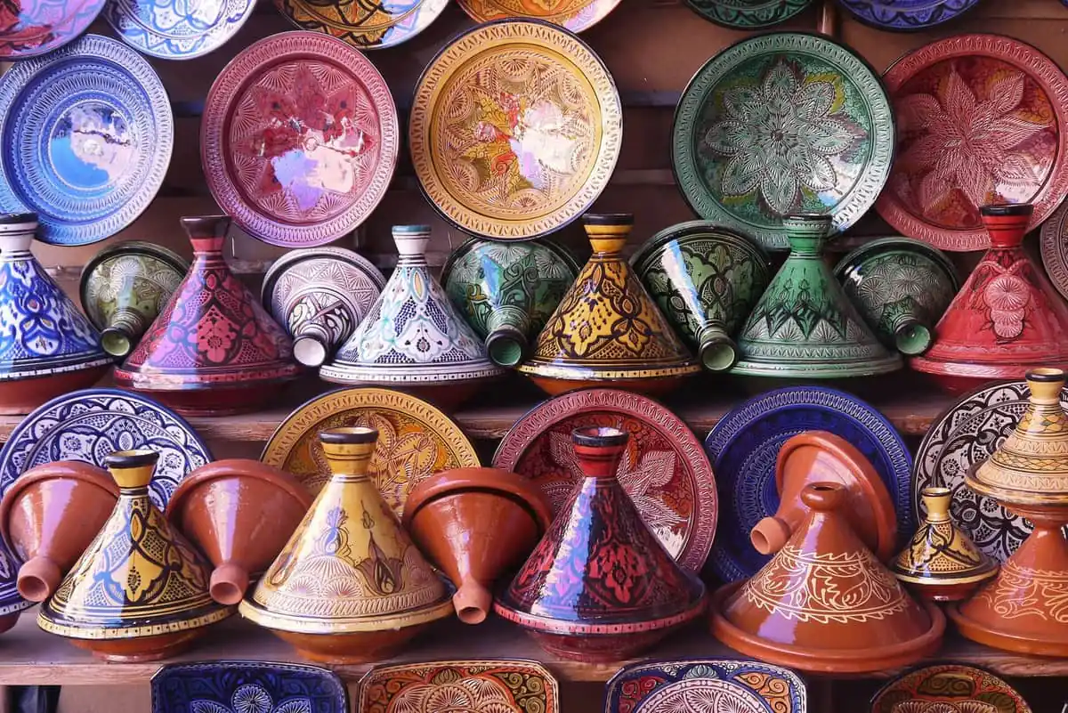 Painted tagine pots and plates stacked in a pottery shop in Morocco